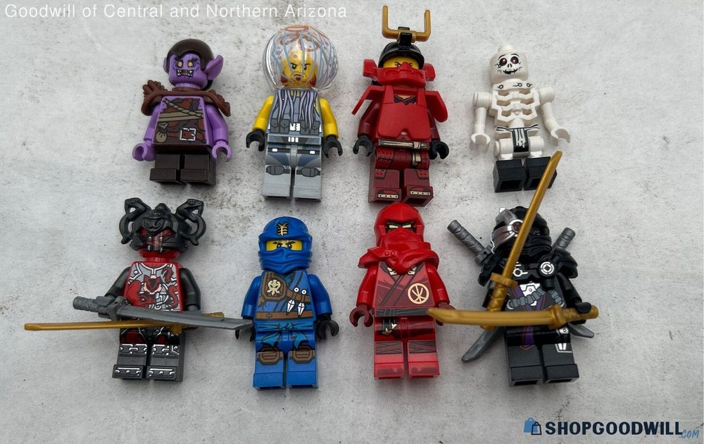 A ShopGoodwill listing photo of eight loose LEGO Ninjago minifigures arranged on a grey background
